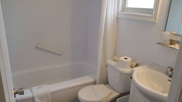 A bathroom with a bathtub, toilet, and sink.
