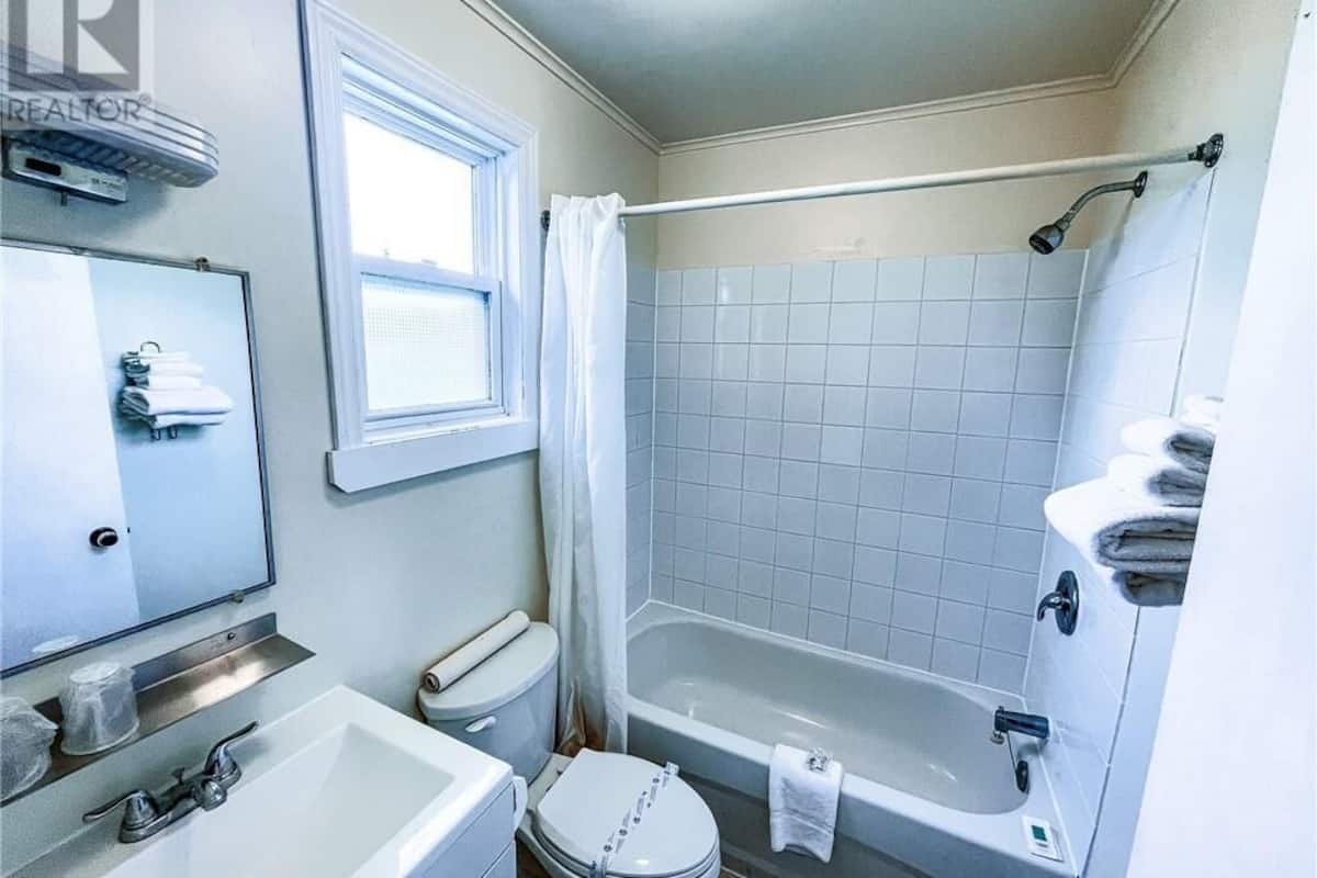 A bathroom with a toilet, sink, and bathtub.