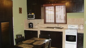 A compact kitchen with a microwave, stove, and sink. - Las Torres Studio (Sardinal)