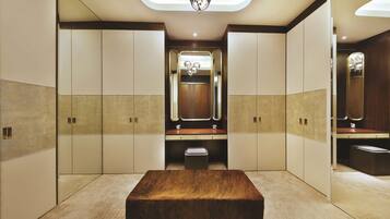 Un baño moderno con un espejo grande, tocador de madera y un banco.
