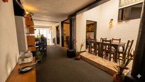 Un couloir meublé de meubles en bois, agrémenté d’une plante en pot et doté d’un sol carrelé.