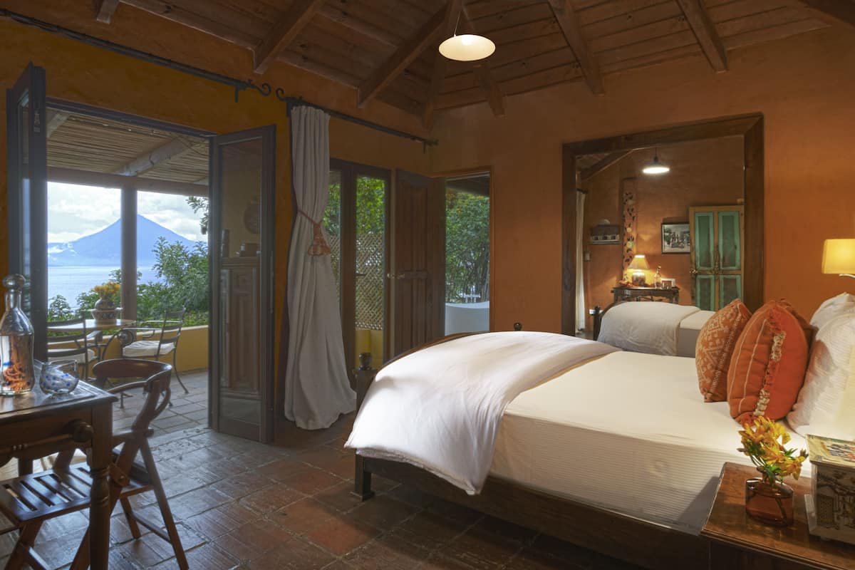 Une chambre avec un lit, un bureau et une vue sur une montagne.