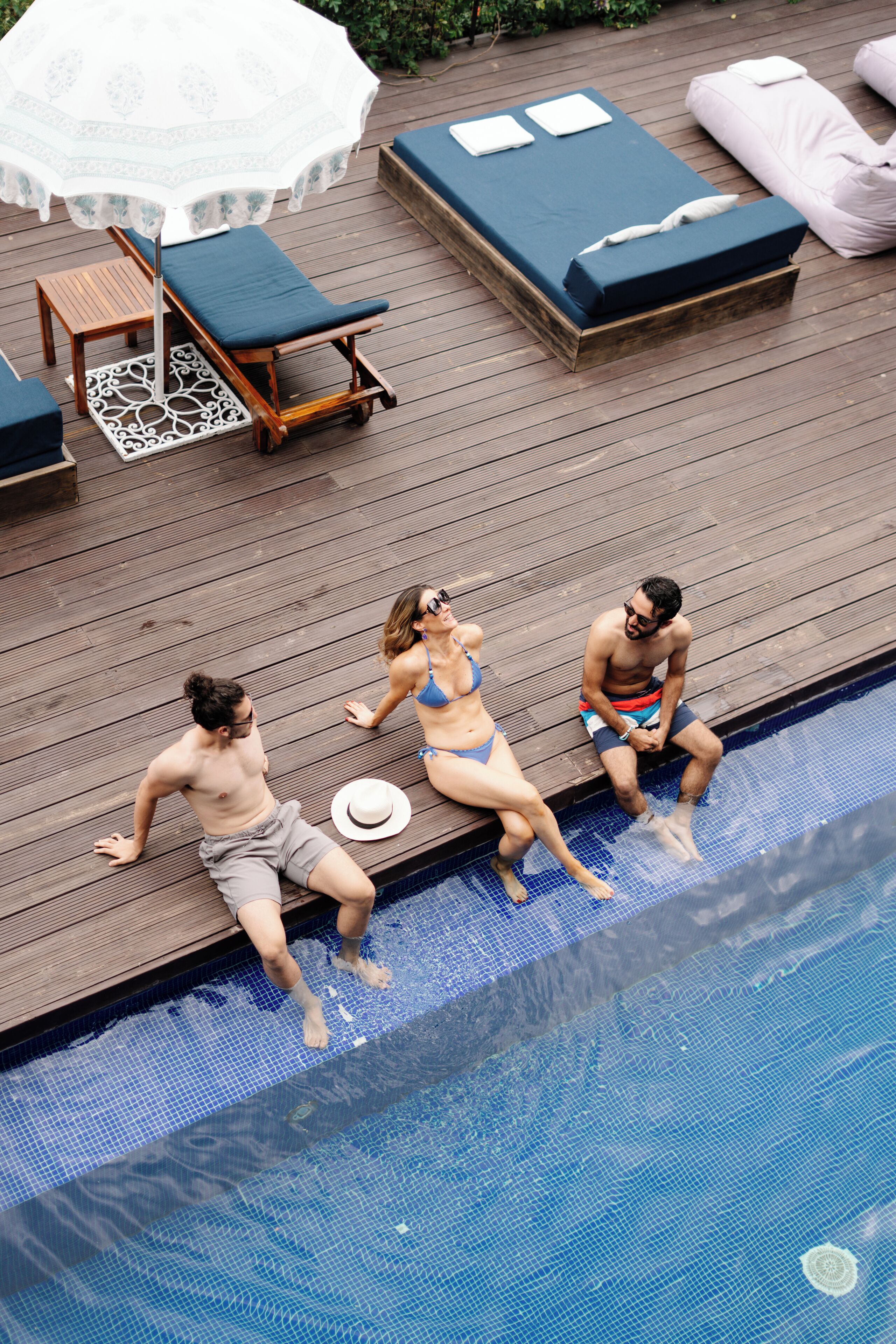 A wooden deck with lounge chairs and a pool.