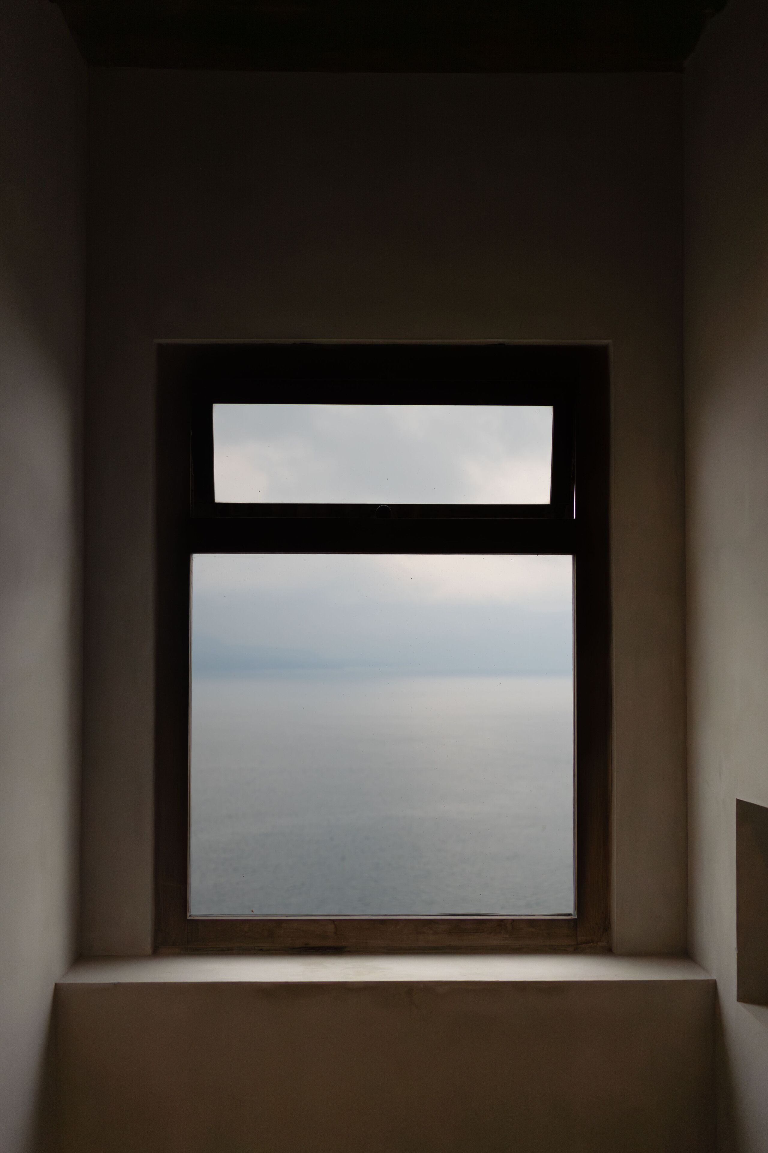 A room with a large window overlooking a body of water.
