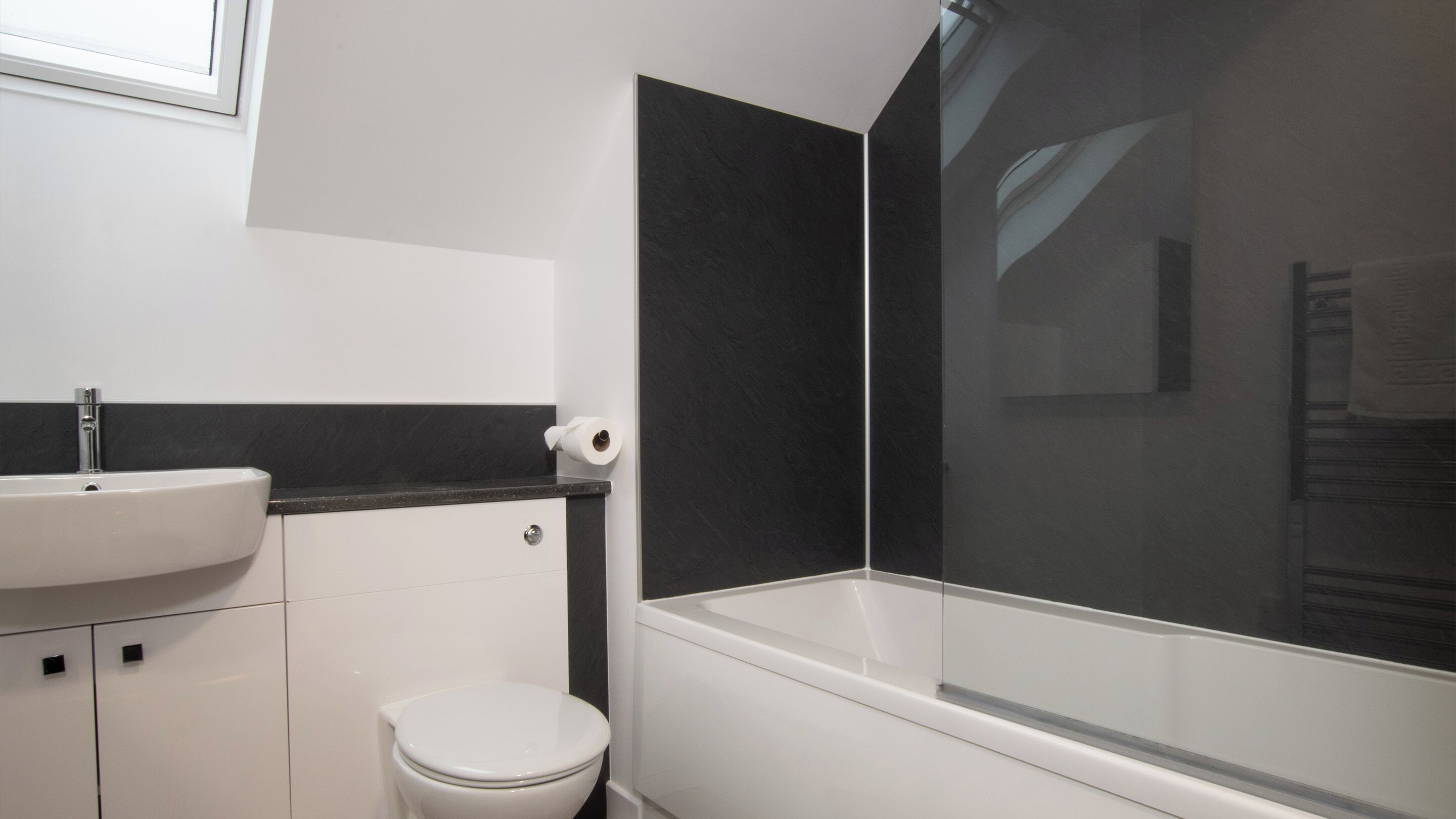 A bathroom with a white sink, toilet, and bathtub.