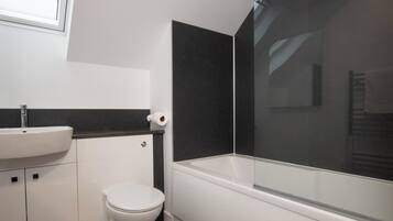A bathroom with a white sink, toilet, and bathtub.