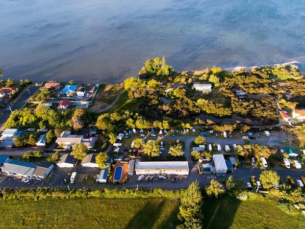 Vista aérea de un camping con vehículos recreativos, piscina y edificios.