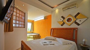 Ein Hotelzimmer mit einem hölzernen Bett, einem großen Fenster mit Vorhängen, einem an der Wand montierten Fernseher und einem Wandbild.