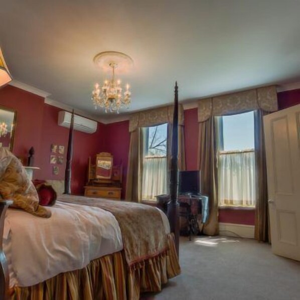 Un dormitorio con cama, cómoda, espejo y candelabro.