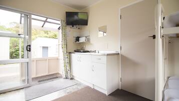 A small kitchenette with a TV, a microwave, and a sink.