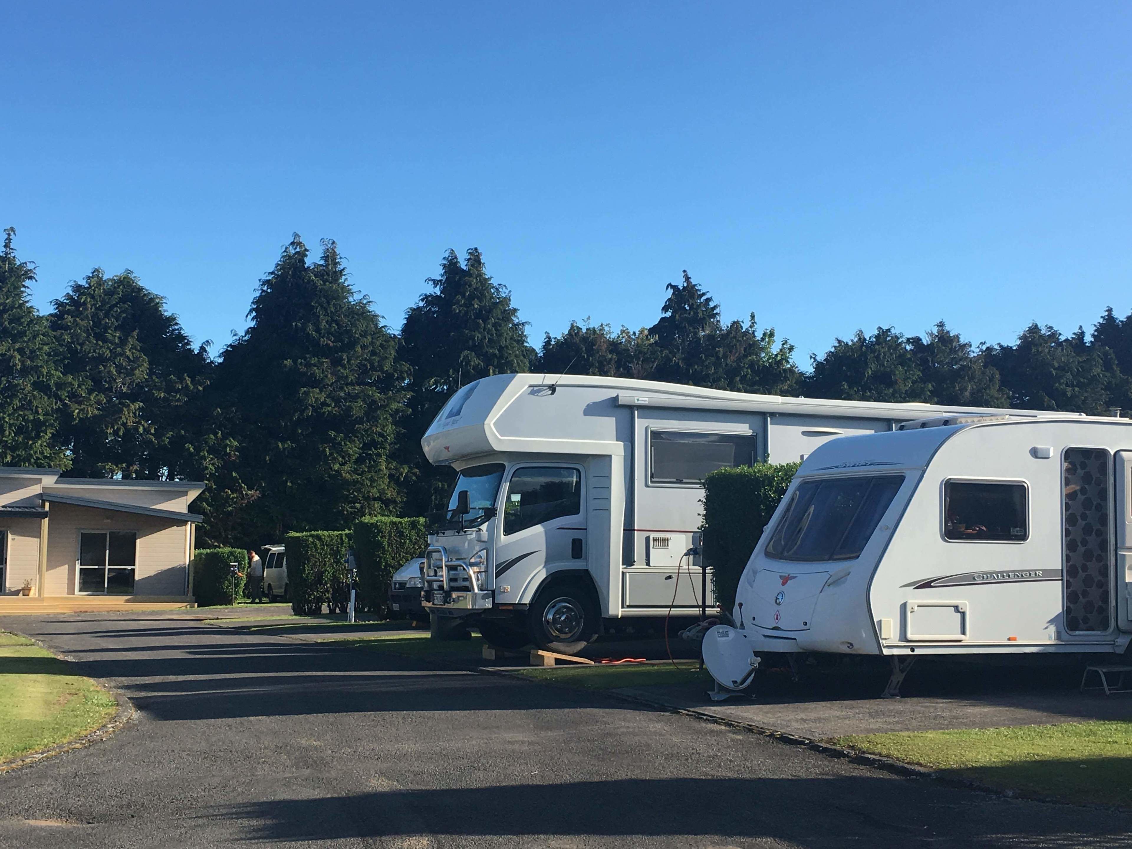 A caravan parked in a parking lot with a building in the background.