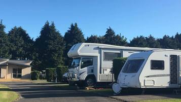 A caravan parked in a parking lot with a building in the background.