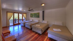 A room with three beds, wooden flooring, a ceiling fan, and a painting on the wall. - Fraser Island Retreat (K'gari (Fraser Island))