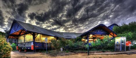 A rustic cabin-style building with a large porch and a covered outdoor seating area.