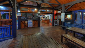 A wooden deck with benches and a wooden structure with a sloped roof. - Fraser Island Retreat (K'gari (Fraser Island))