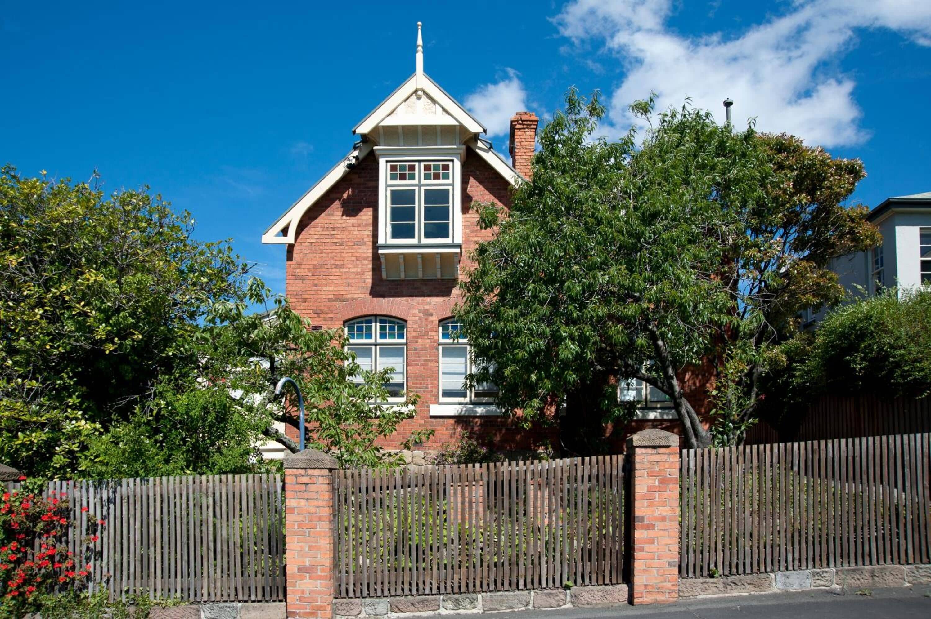A brick house with a gabled roof and a central window.