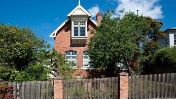 A brick house with a gabled roof and a central window.
