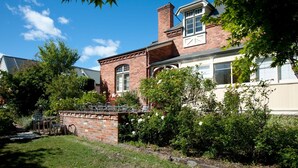 A brick house with a large front yard, a covered patio, and a garage. - Lowena Cafe and Accommodation (Hobart)