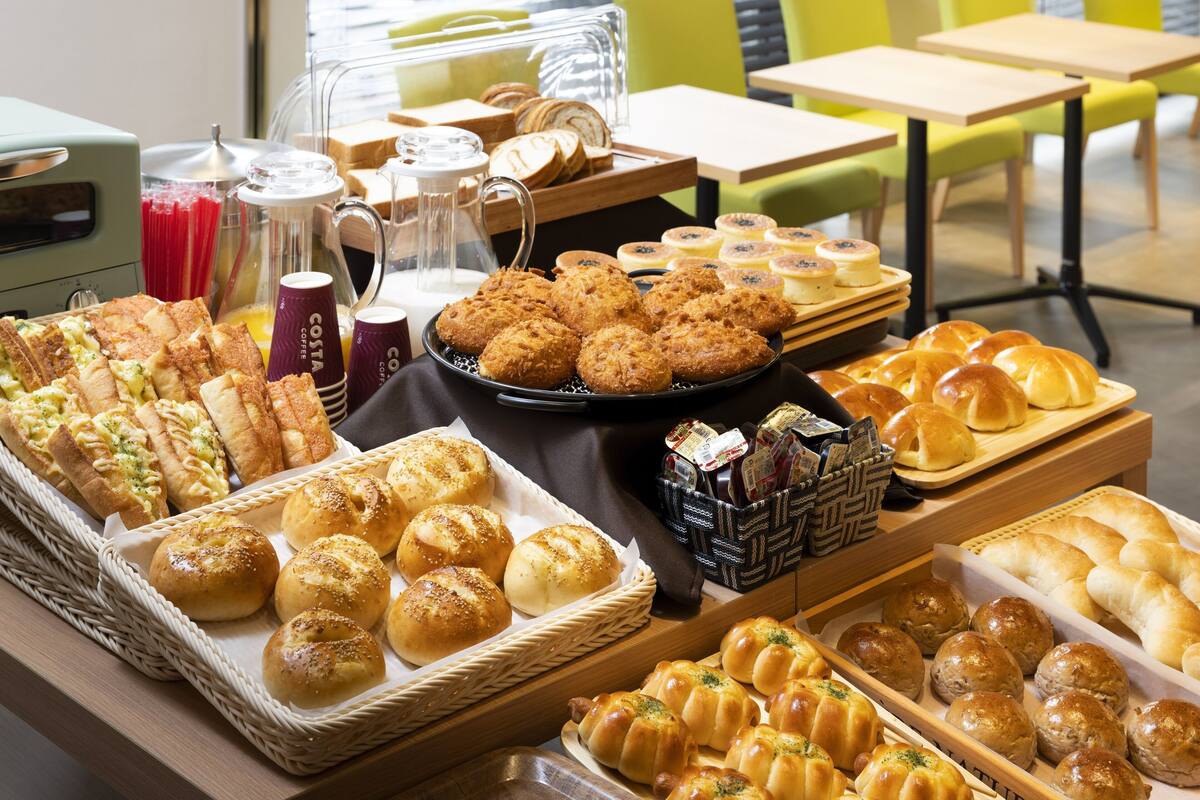 A buffet with various baked goods, including bread, pastries, and rolls.