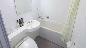 A small, clean bathroom with a white sink, toilet, and bathtub. There are toiletries on the sink counter.