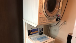 A compact, white, wall-mounted washing machine with a control panel and a coin slot. - Shizutetsu Hotel Prezio Shizuoka Station Kita (Shizuoka)