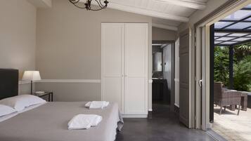 A bedroom with a large bed, a wardrobe, and a bathroom visible through an open door.