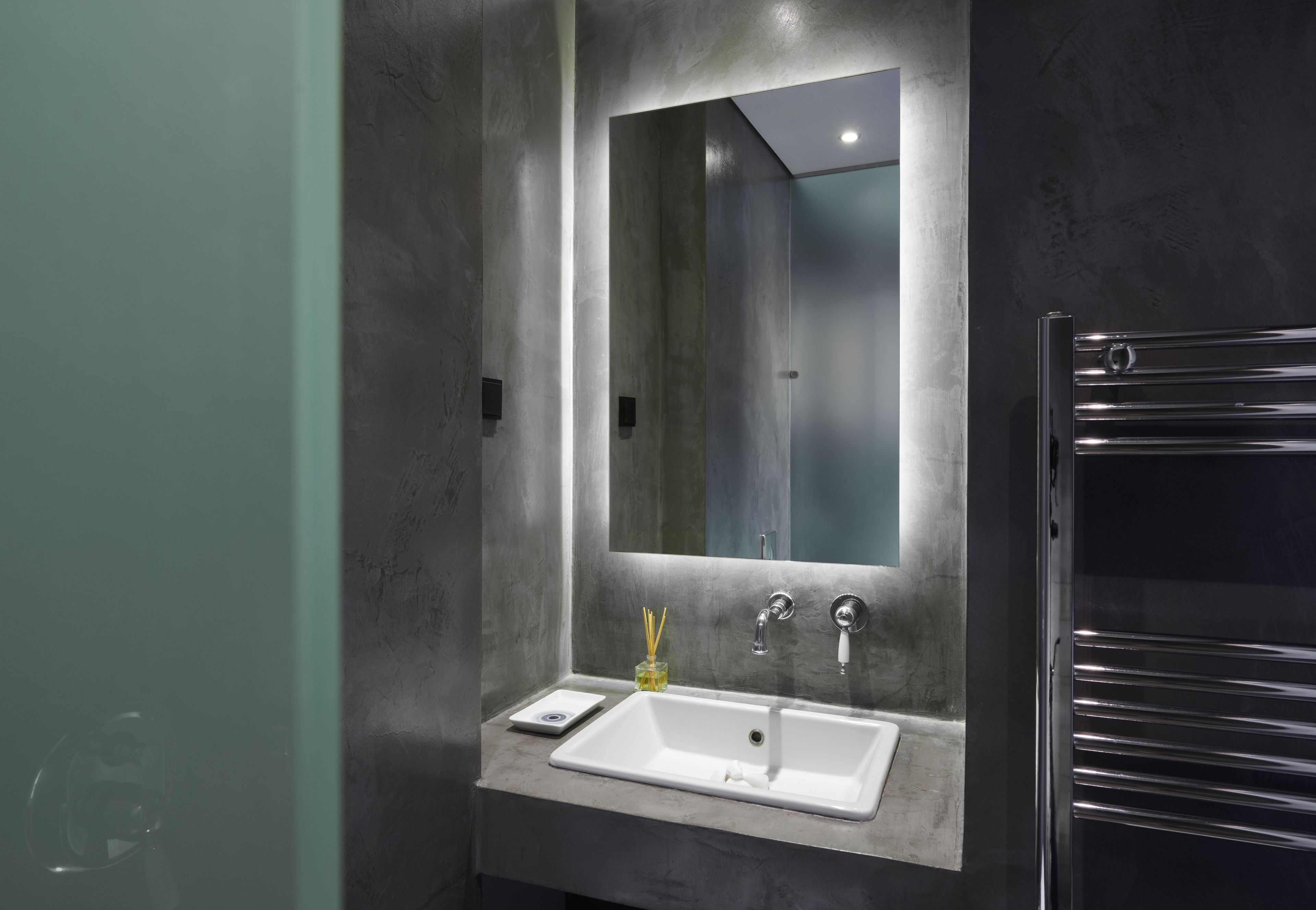 Een moderne badkamer met een rechthoekig wastafelmeubel, een spiegel en een handdoekrek.