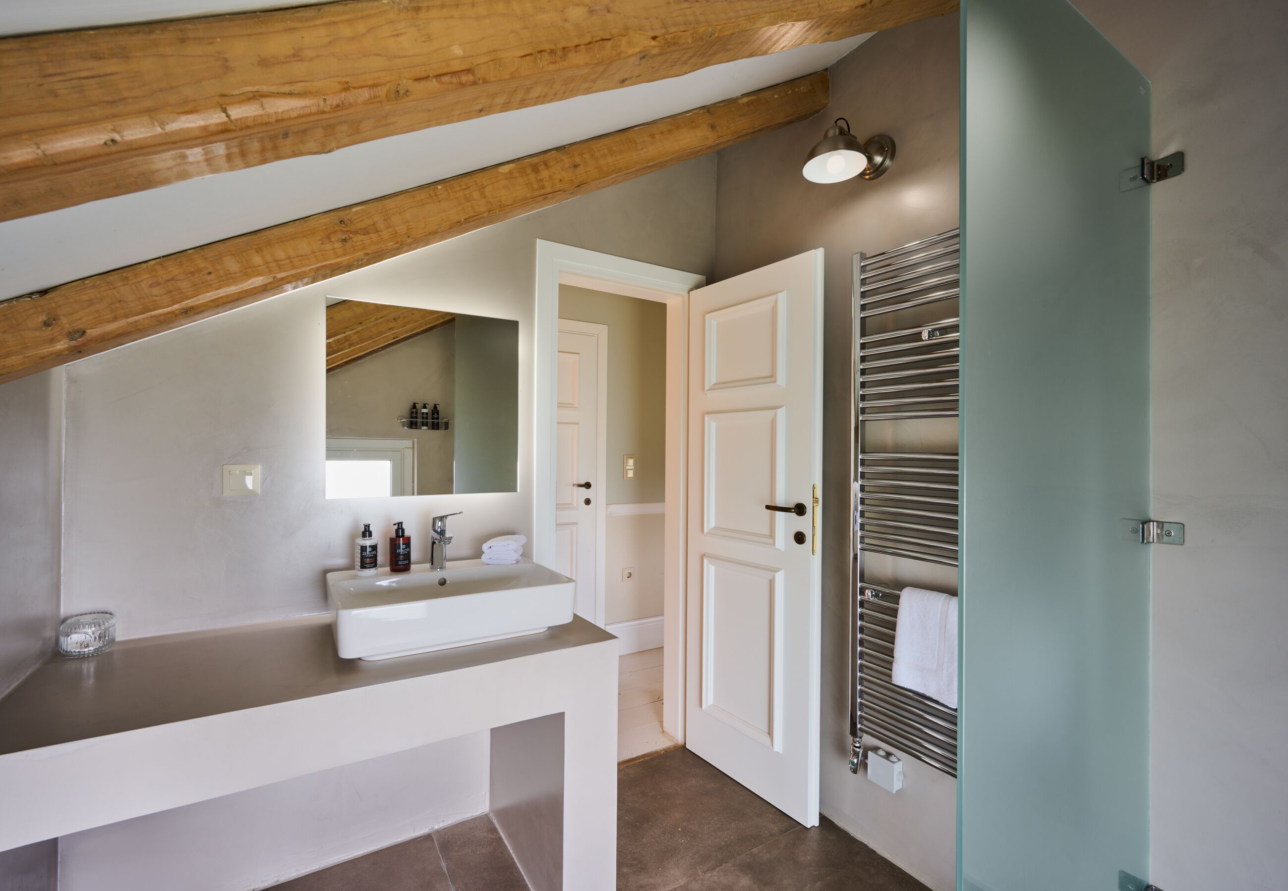 A bathroom with a white sink, mirror, and towel rack.