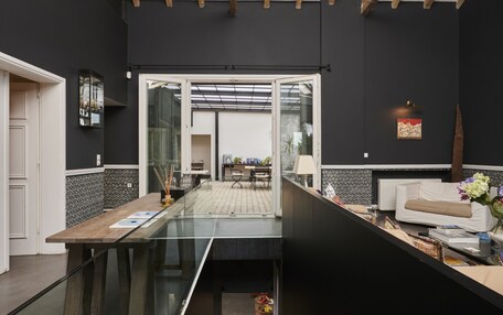 A modern kitchen with a central island, a dining area with a table and chairs, and a living area with a sofa and a coffee table.
