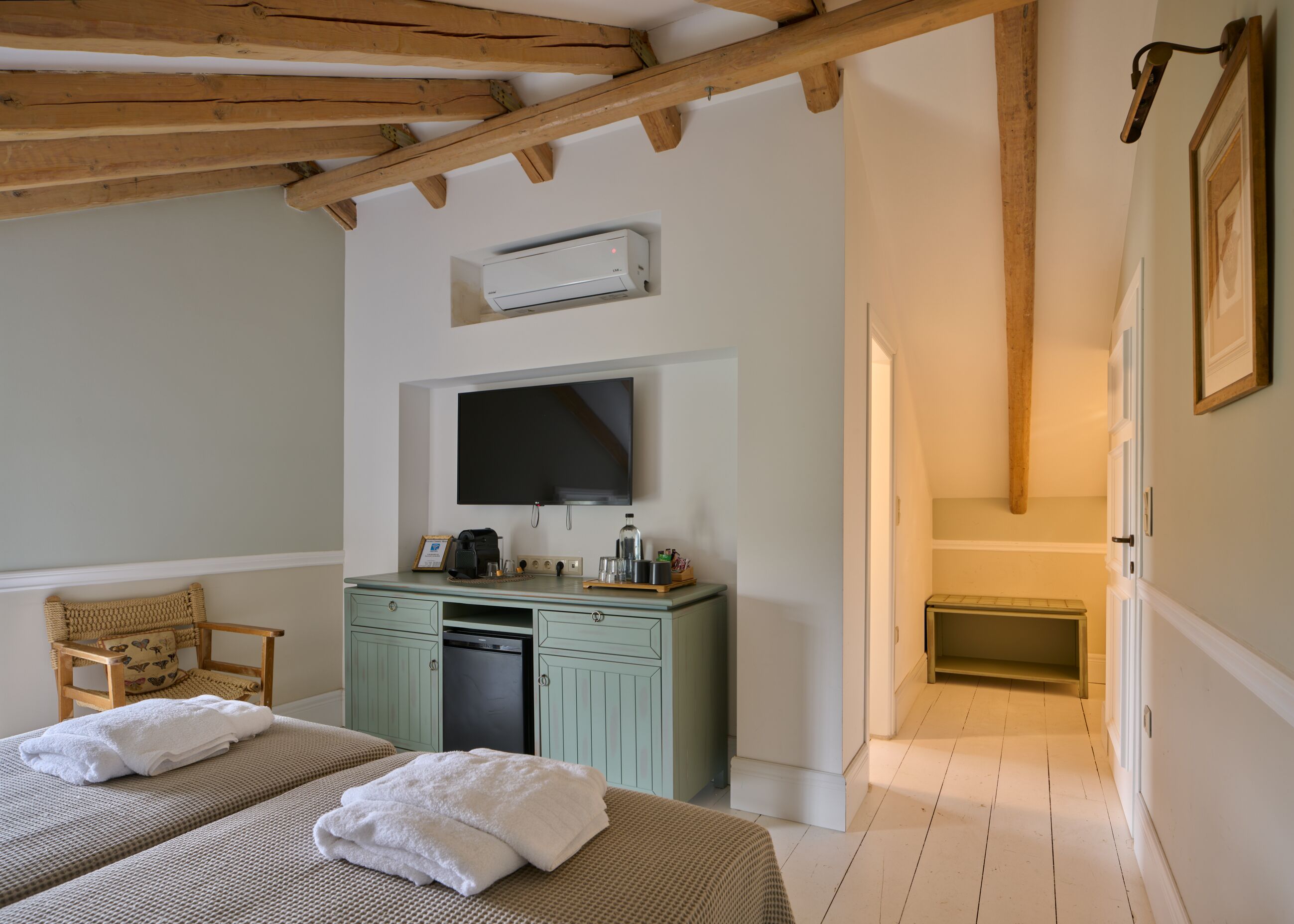 Een slaapkamer met een bed, een bureau met een computer, een televisie en een open haard.