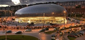 Ein großes, modernes Stadion mit einer markanten, gebogenen Glasfassade.