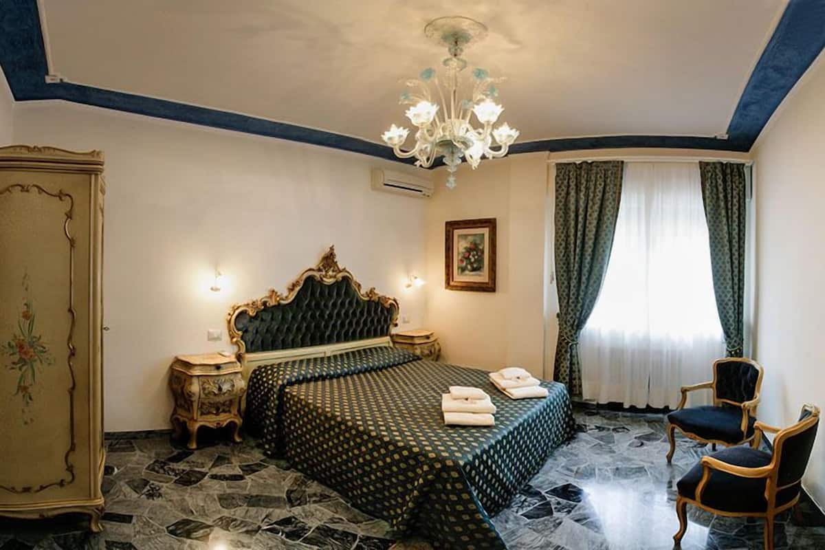 Un dormitorio con cama, candelabro, armario y una silla.