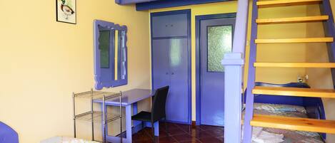 A room with bunk beds, a desk, and a chair.