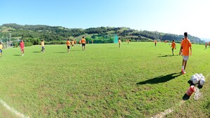 A soccer field with players in orange and red uniforms. - Finca El Mazo (Voto)