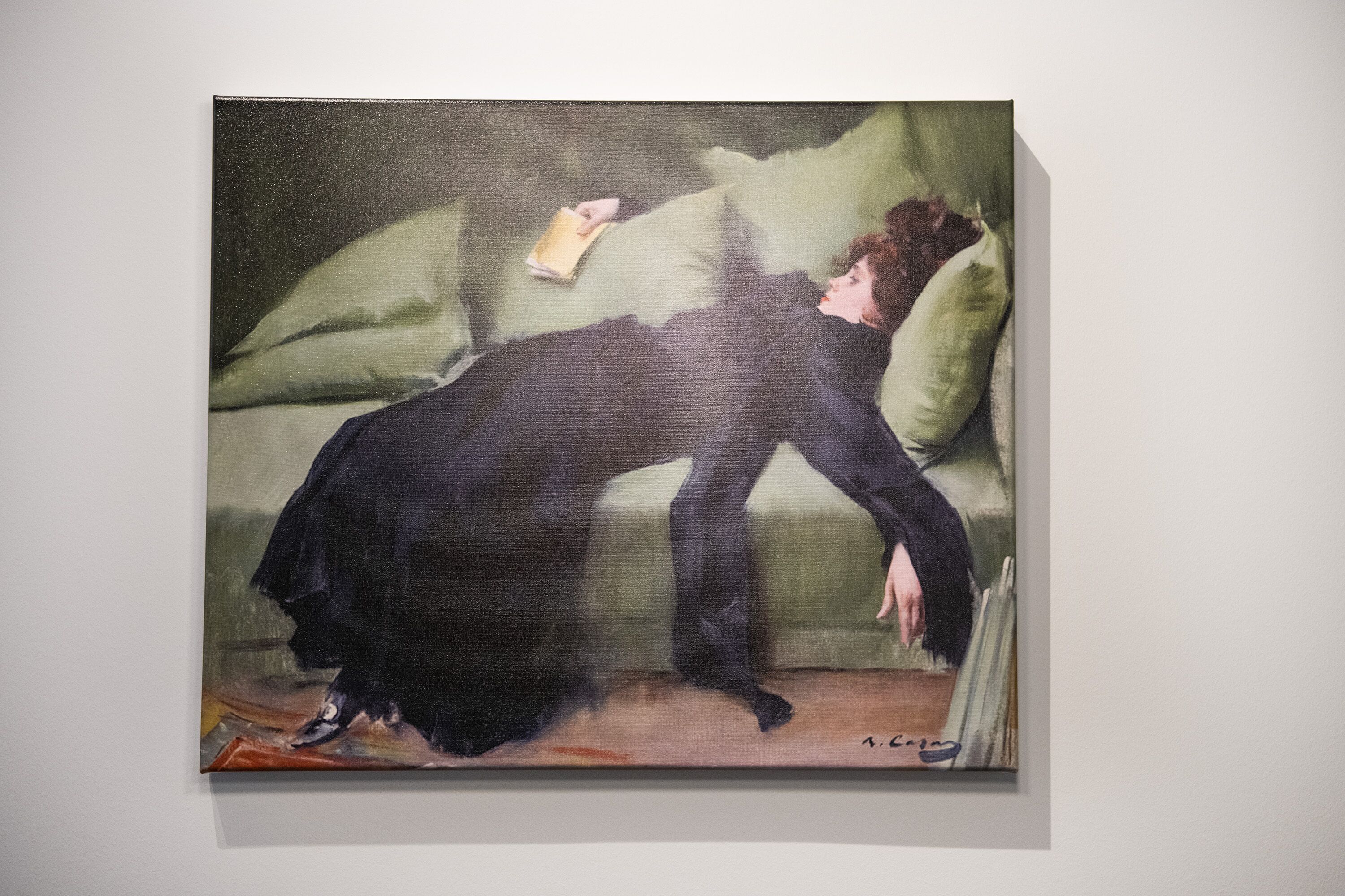Una pintura de una persona recostada en un sofá leyendo un libro.