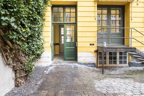 A narrow cobblestone path leading to a building with a green door and a small staircase. - Churchill Studio by Daniel&Jacob's (Copenhagen)