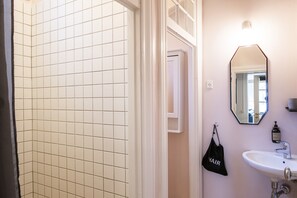Familie appartement | Badkamer | Een douche, een haardroger, handdoeken