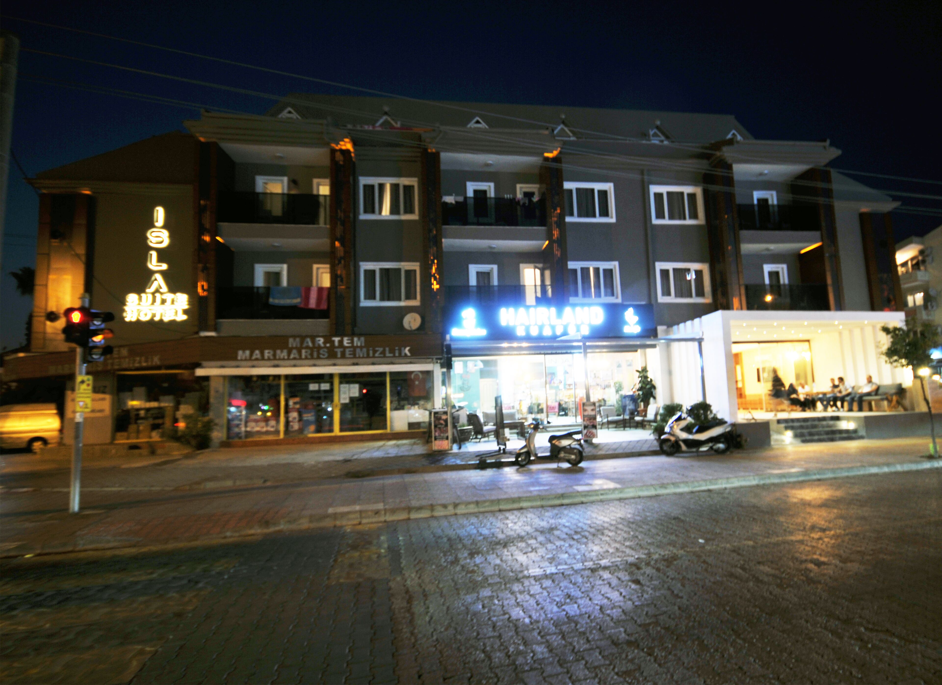 A multi-story hotel with a prominent sign for 'Hairland'.