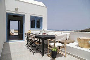 En terrasse med et bord, stole og en fletkurv.