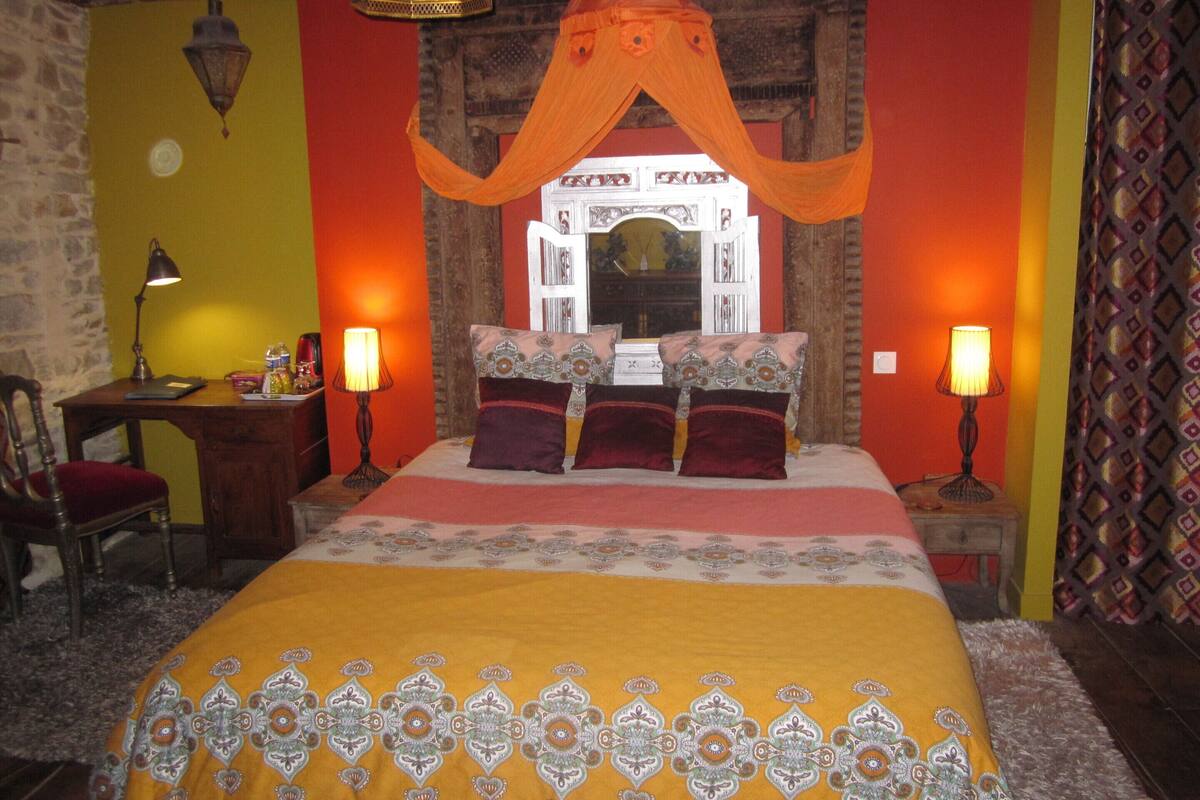 Une chambre traditionnelle avec un lit, deux lampes de chevet, un bureau et une chaise.