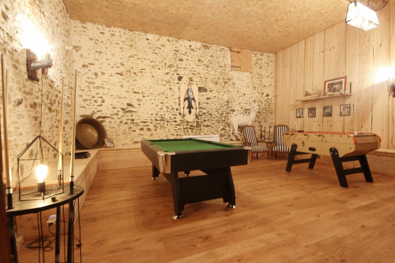 A room with a pool table, two foosball tables, and a billiards table.