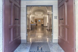 Una entrada imponente con piso de mármol y un cartel que dice "Martis Palace".