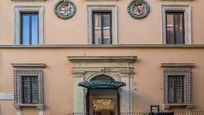 A building facade with three windows, each with a wreath above. - Martis Palace Hotel (Rome)