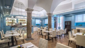 A spacious restaurant with high ceilings, large windows, and a bar area. - Martis Palace Hotel (Rome)