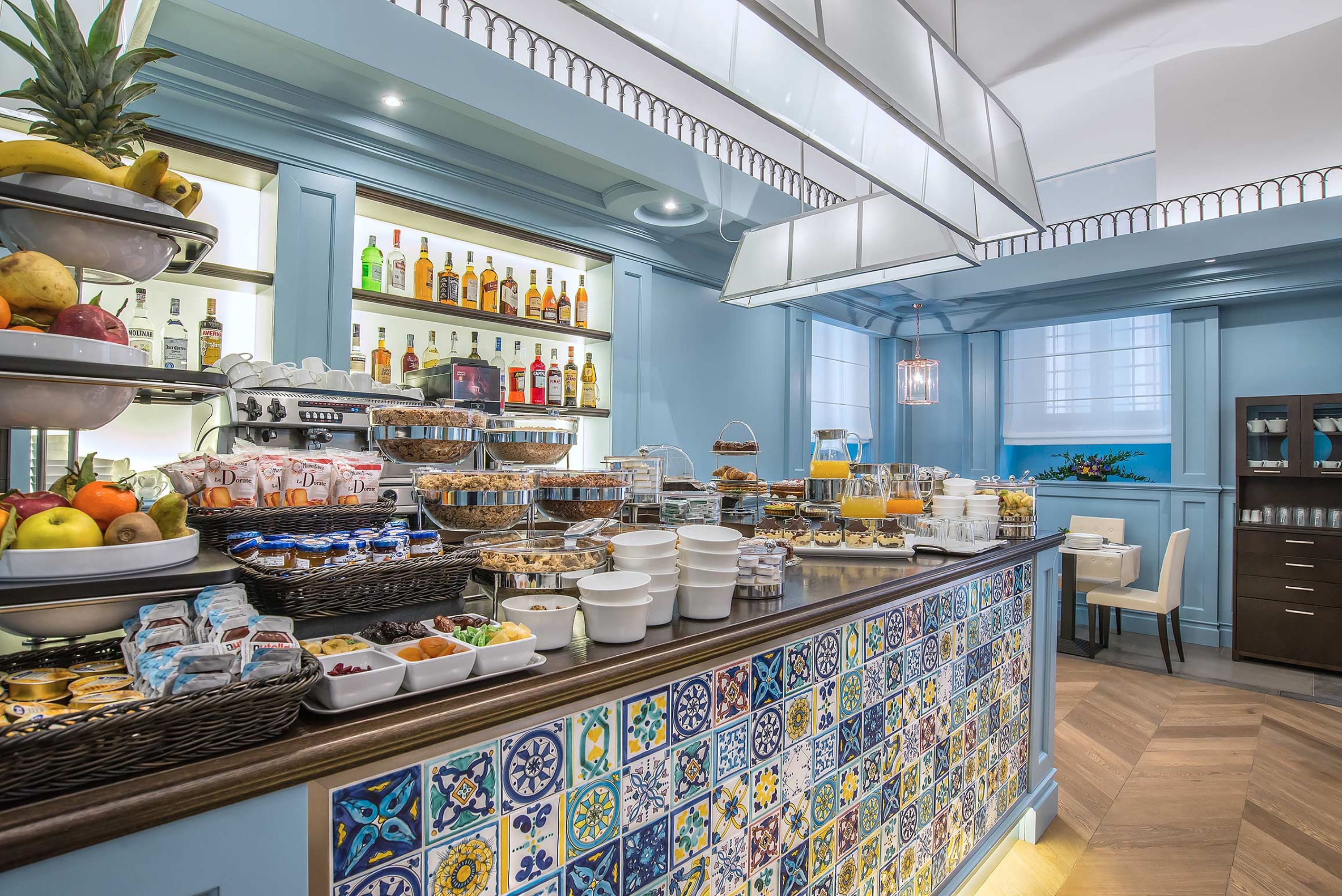 A breakfast bar with a variety of food and drink options, a tiled backsplash, and a view of the room.