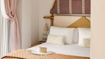 A neatly made bed with a patterned blanket, a wooden headboard, and a ceiling fan.