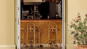 Ein Restaurant mit Eingangsbereich, einer Schilder mit der Aufschrift 'MONTESOL', einer Bar mit Hockstühlen und einem Blumentopf.