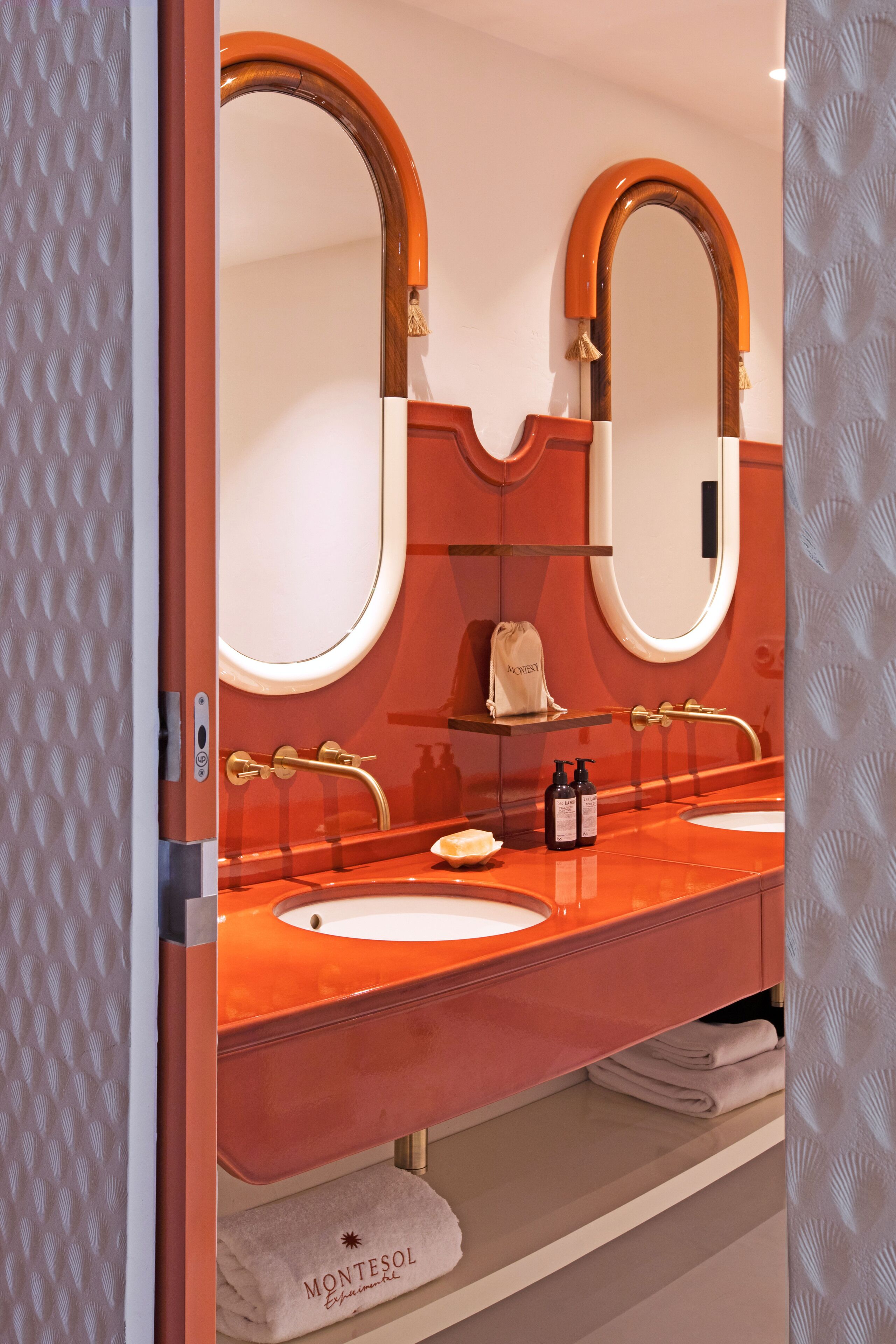 A bathroom with two sinks, a large mirror, and a towel rack.