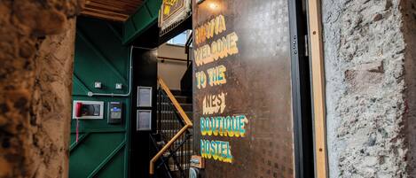 A reception area with a sign welcoming to the West Boutique Hostel.