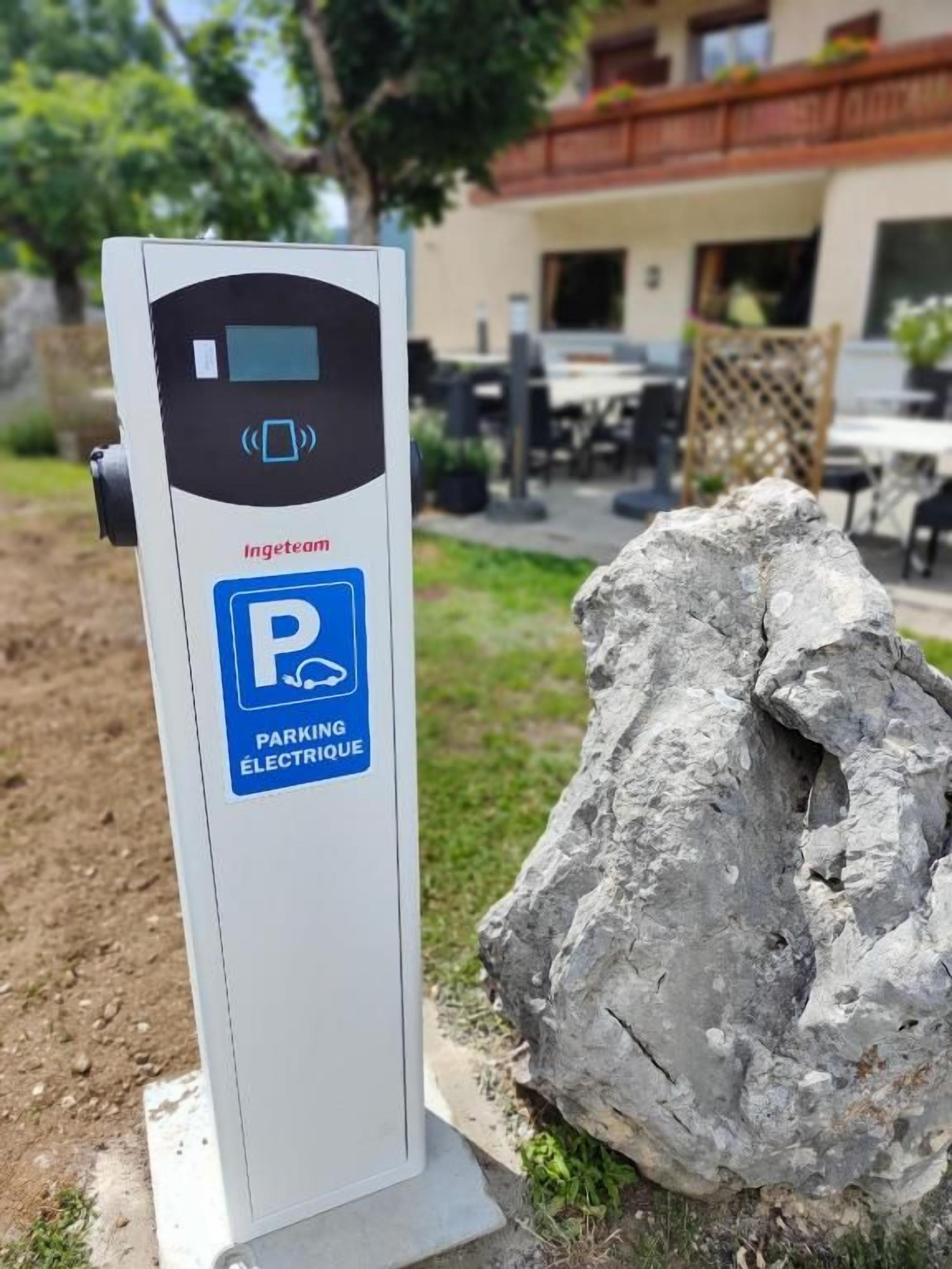 Estação de carregamento para carro elétrico com placa indicando 'Ingeteam' e 'PARKING ÉLECTRIQUE', com símbolo de estacionamento azul.